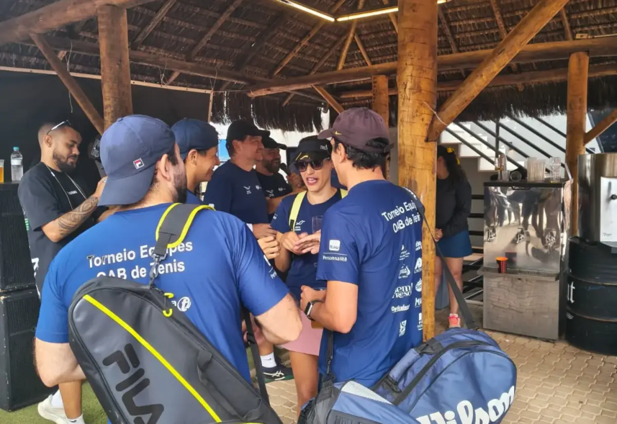 Jogadores de camisa azul do Torneio Equipes OAB conversando sob o quiosque